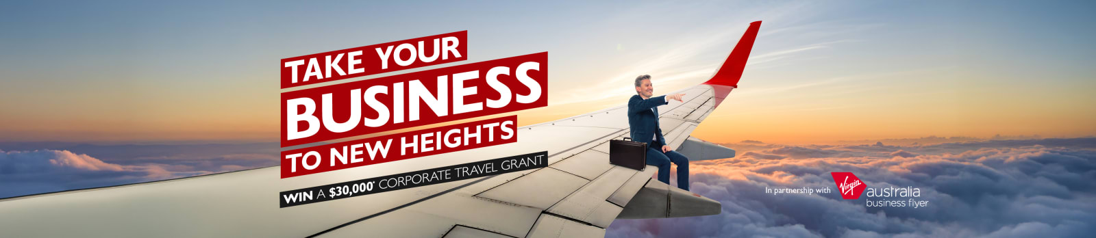 Take your business to new heights | win a $30,000* corporate travel grant. Businessman sitting on the wing of a plane