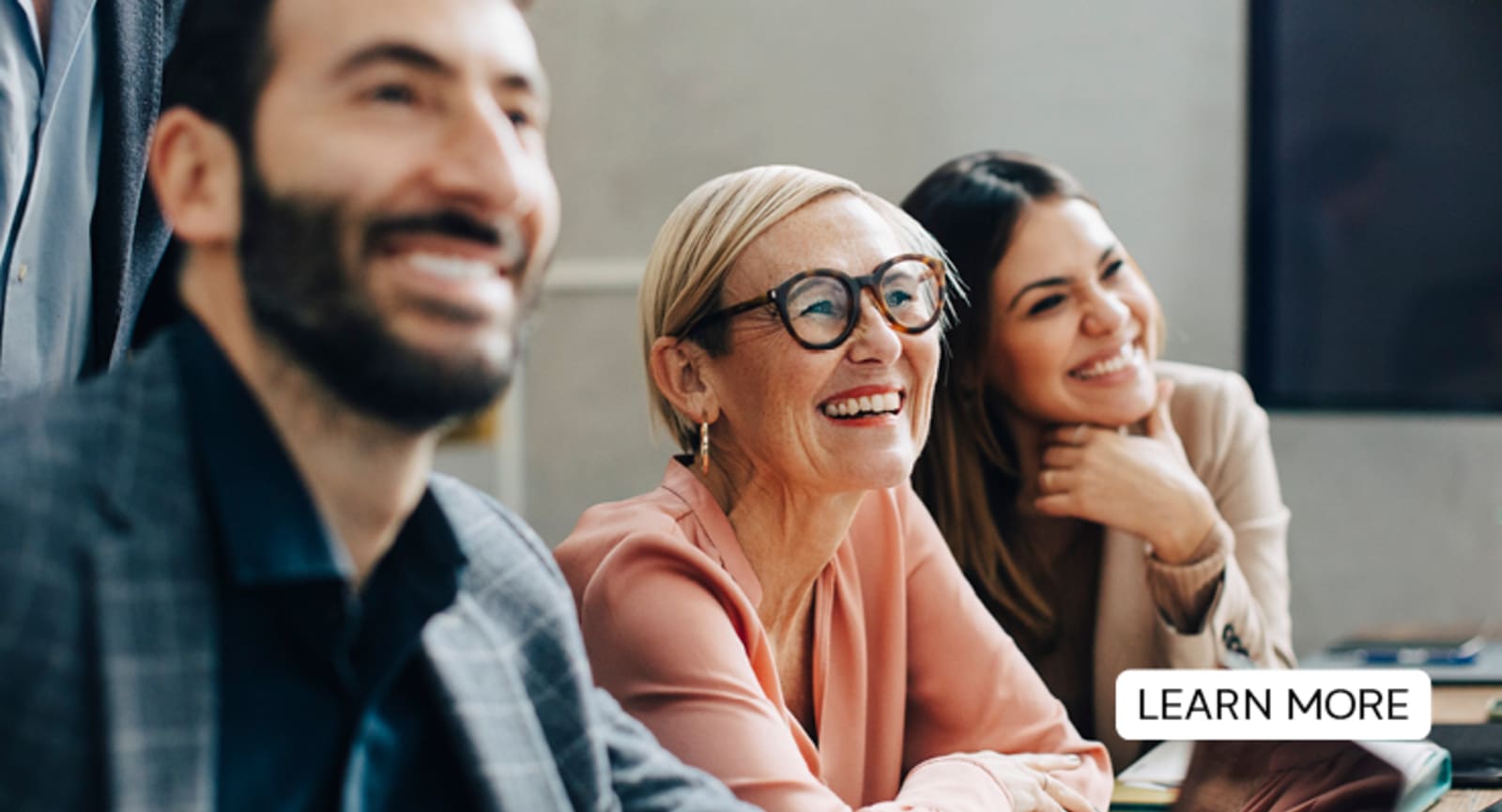 Businesspeople smiling looking at something out of frame