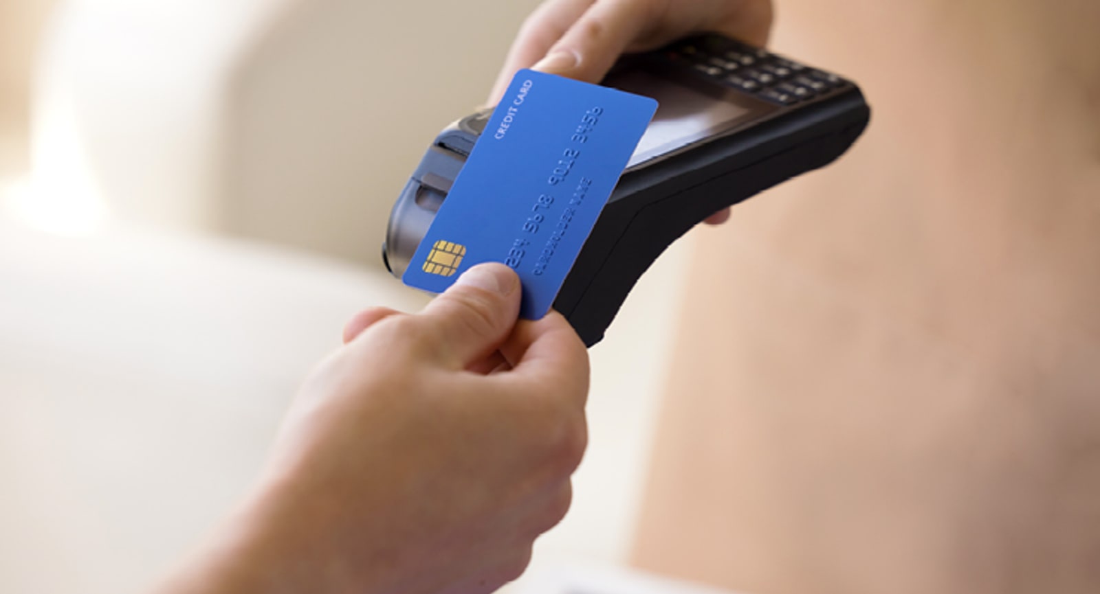 Blue credit card being tapped on an EFTPOS machine