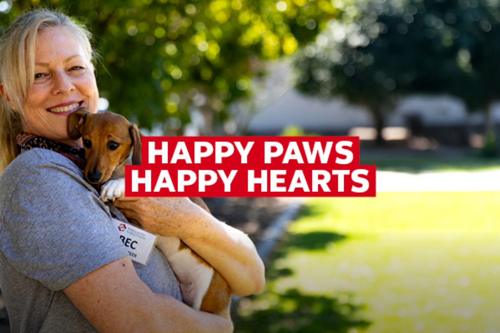 Happy Paws, Happy Hearts - woman smiling, holding her puppy dog