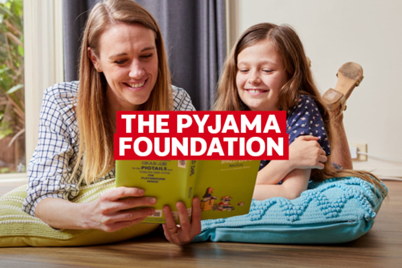The Pyjama Foundation | mother and daughter lying on the floor, reading a book