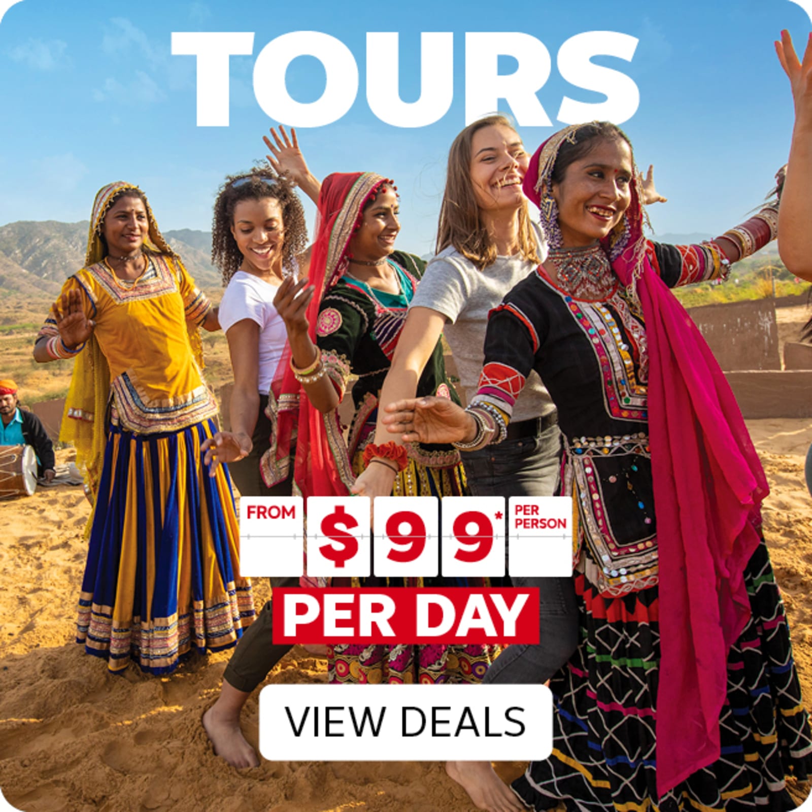 Women smiling and dancing in a line in the desert, several dressed in colourful traditional dresses