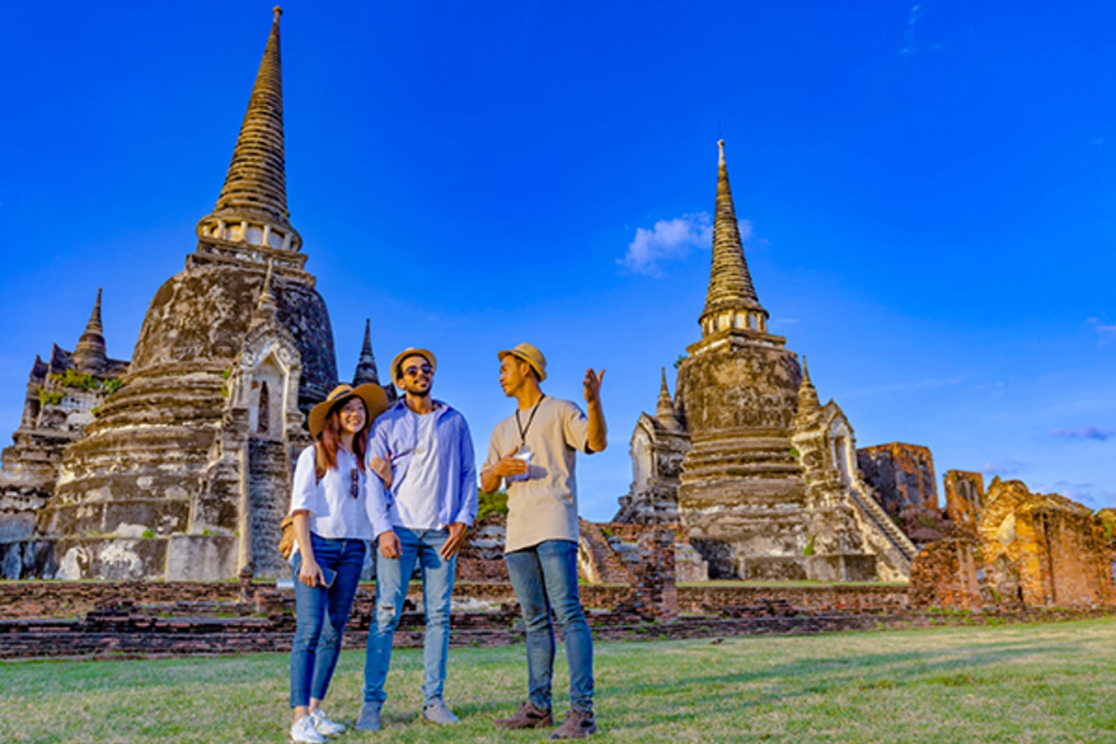 Tour guide talking to a couple in front of a temple in Thailand