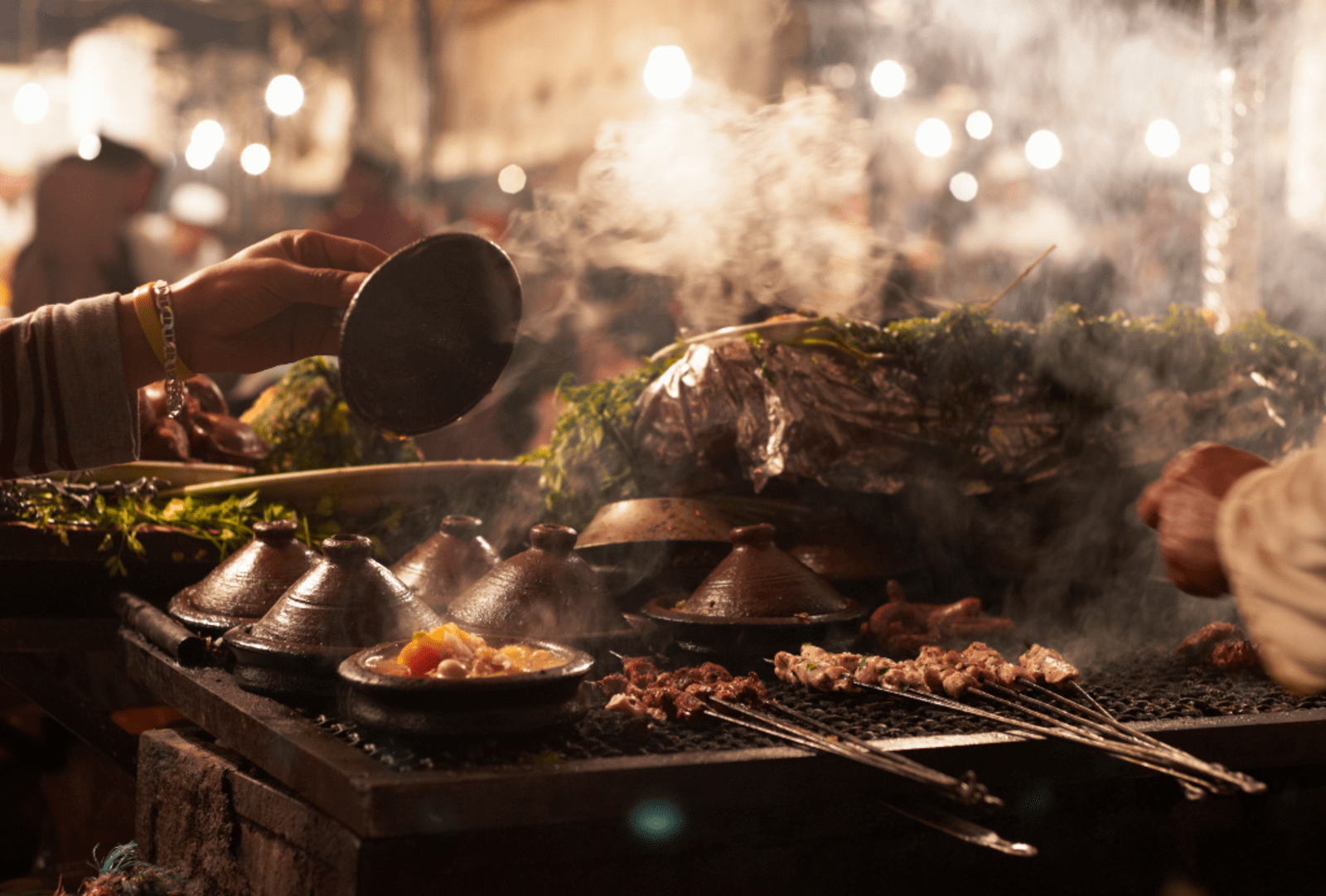 Traditional Tagine and Kebabs cooking on an open market stall at night