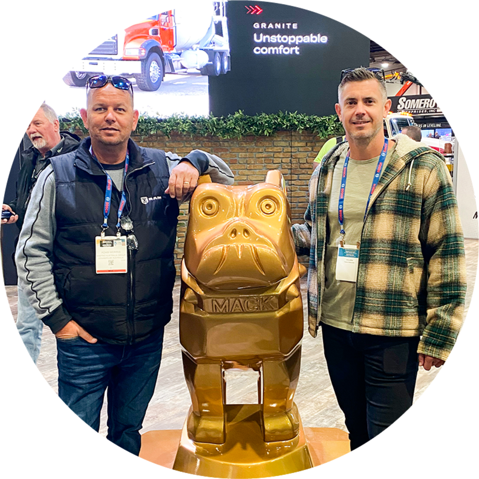 Two men standing aside a golden cartoon dog statue