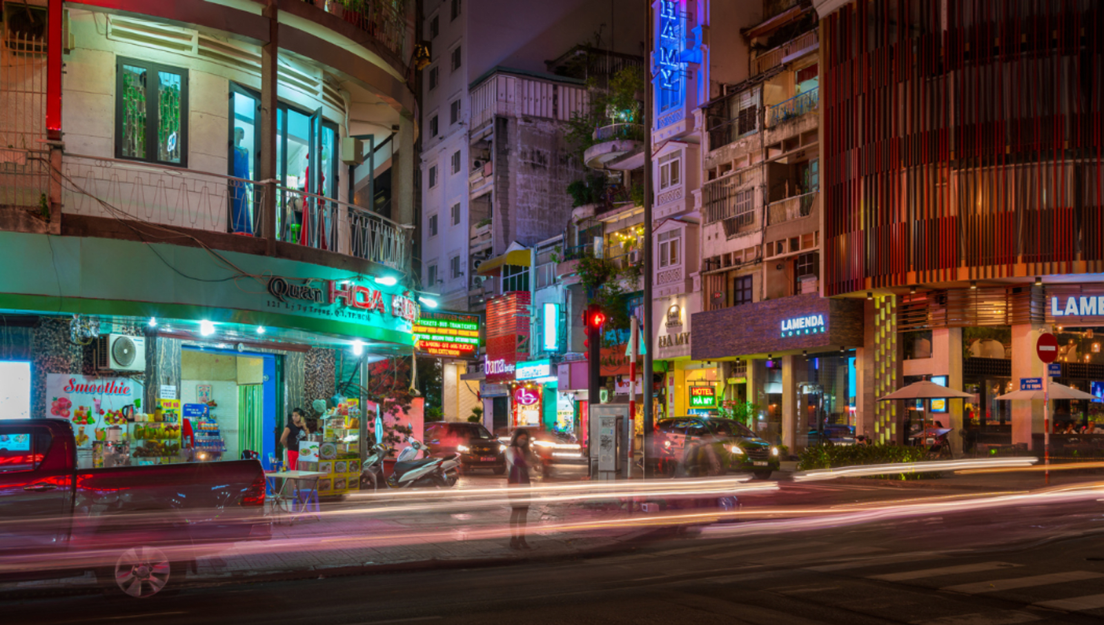 Lady waiting to cross the road on a busy street in Ho Chi Minh city vietnam at night
