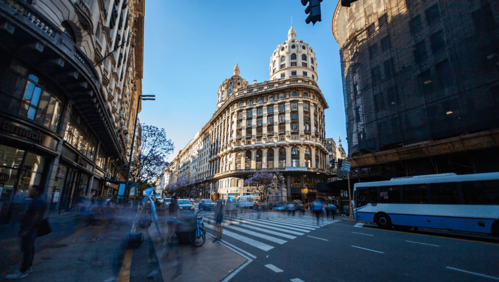 View of traffic and pedestrians on street with big european style building in background