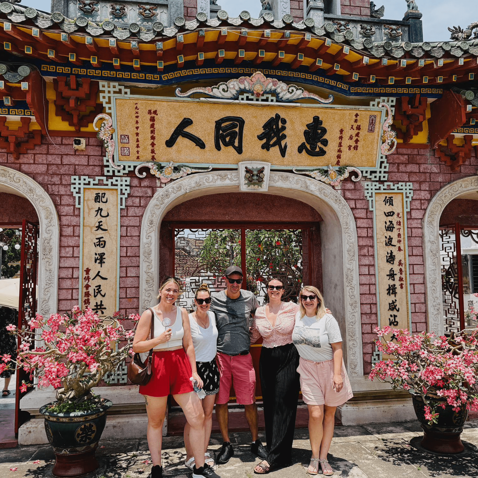 Tourists standing in front of a temple gate in Hoi An, Vietnam