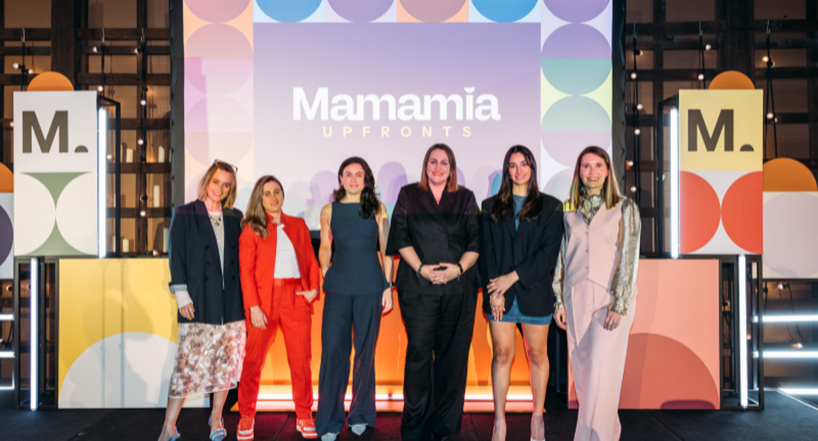 Women from the business Mamamia standing on a stage