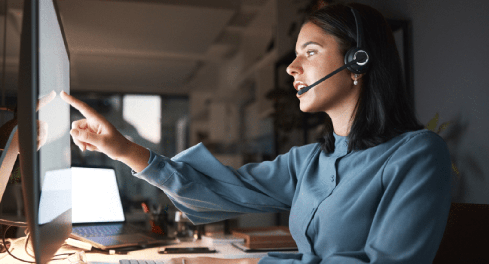 Woman wearing a headset using a large touch screen