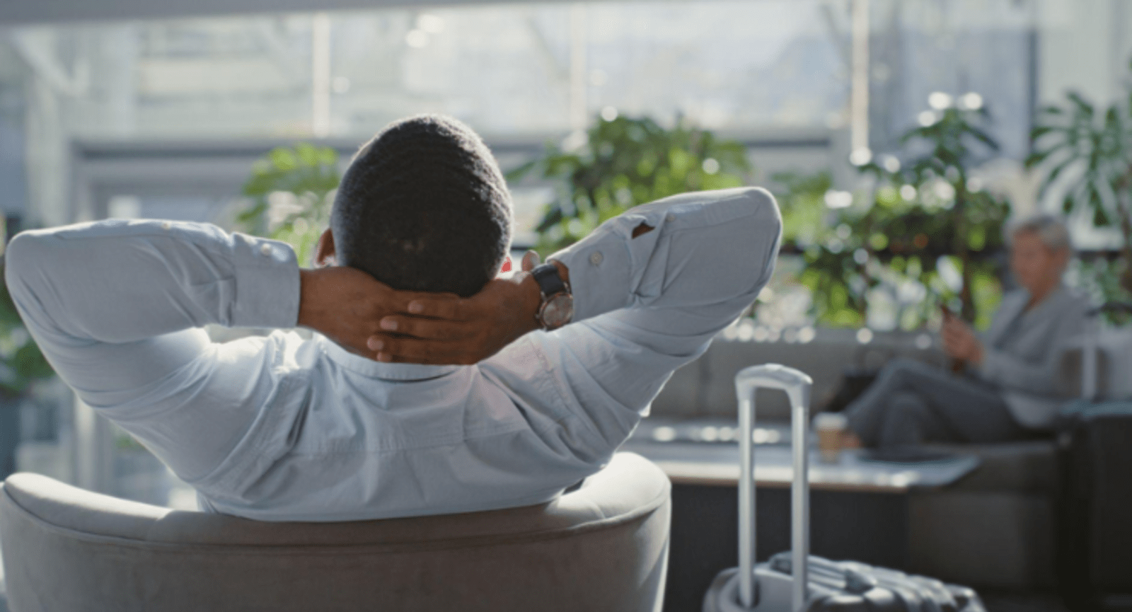 Shot from behind on a man relaxing with his hands behind his head