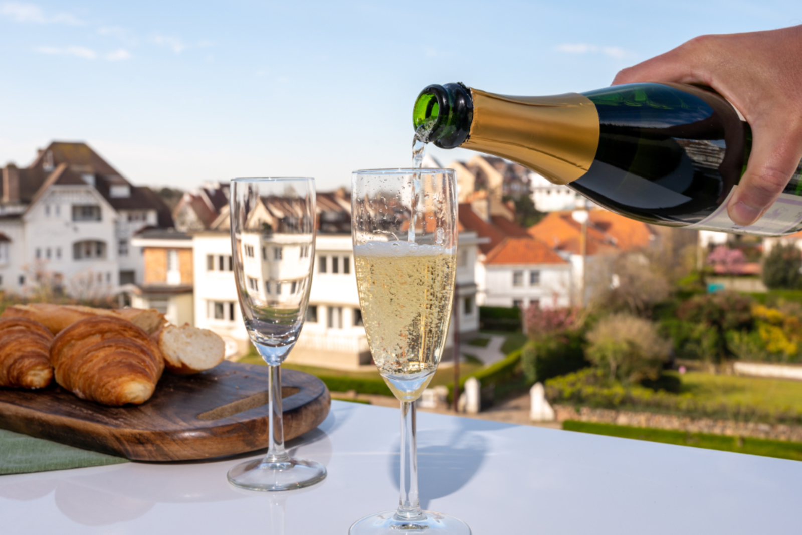 A person pouring glasses of Champagne on a terrace in France