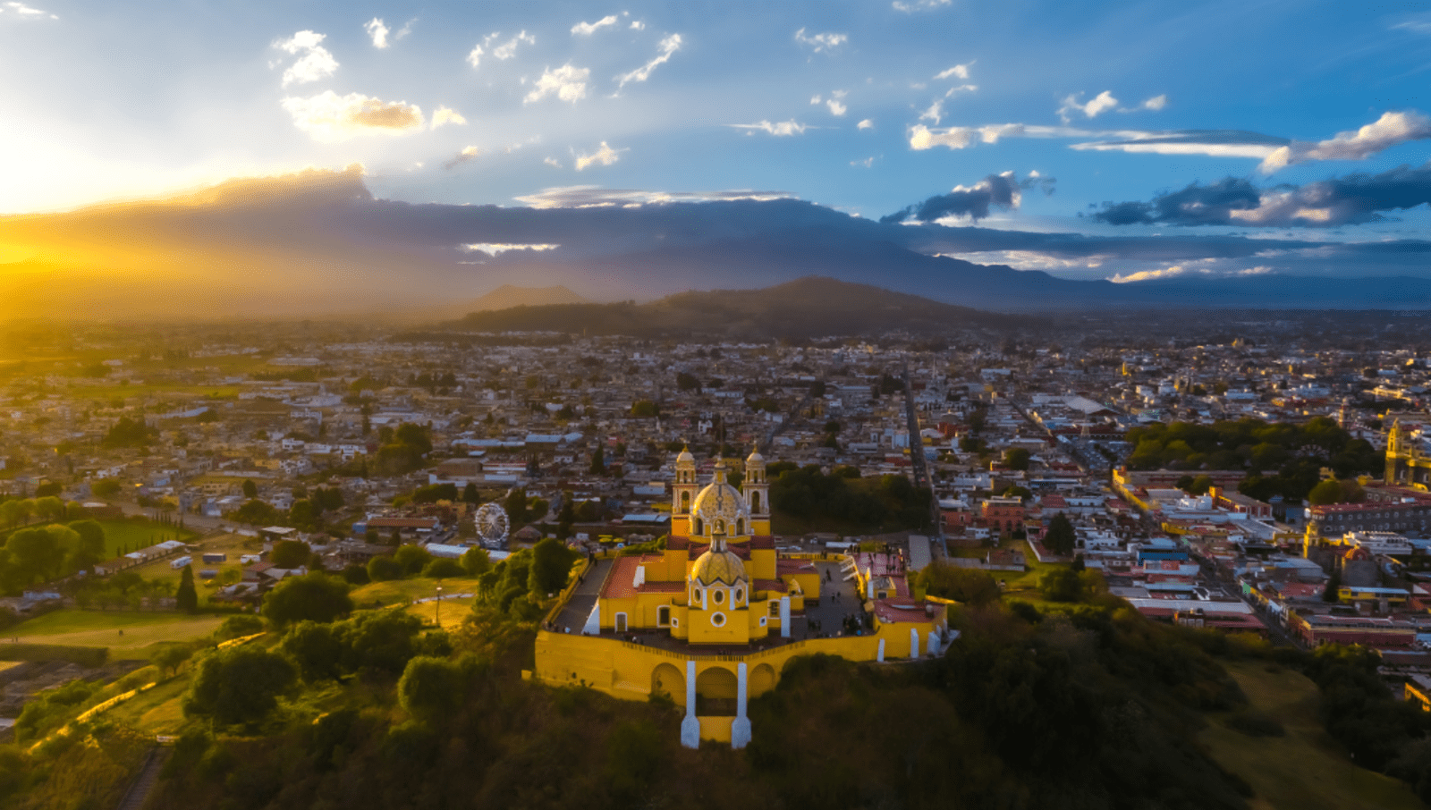 Downtown Puebla Mexico city scape with mountains in background at sunset