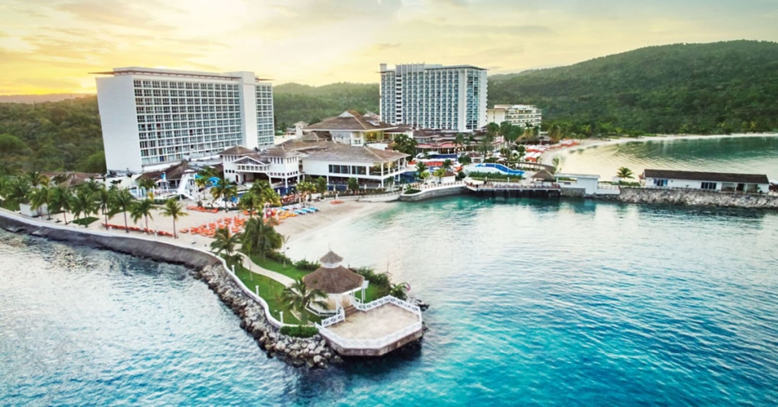 Moon Palace Hotel in Jamaica - two white rectangular hotels alongside a coastline, with pagodas, palm trees and forest in the background