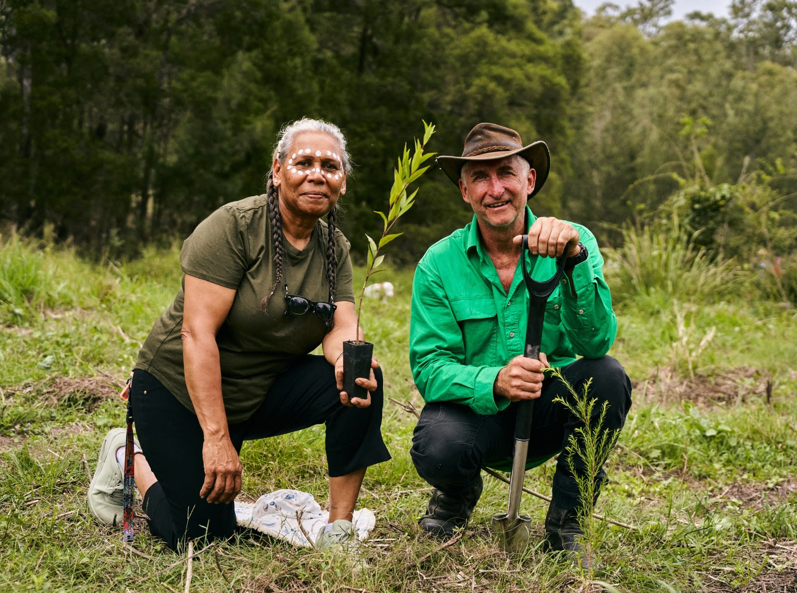 lady and man kneeling by tree being planted