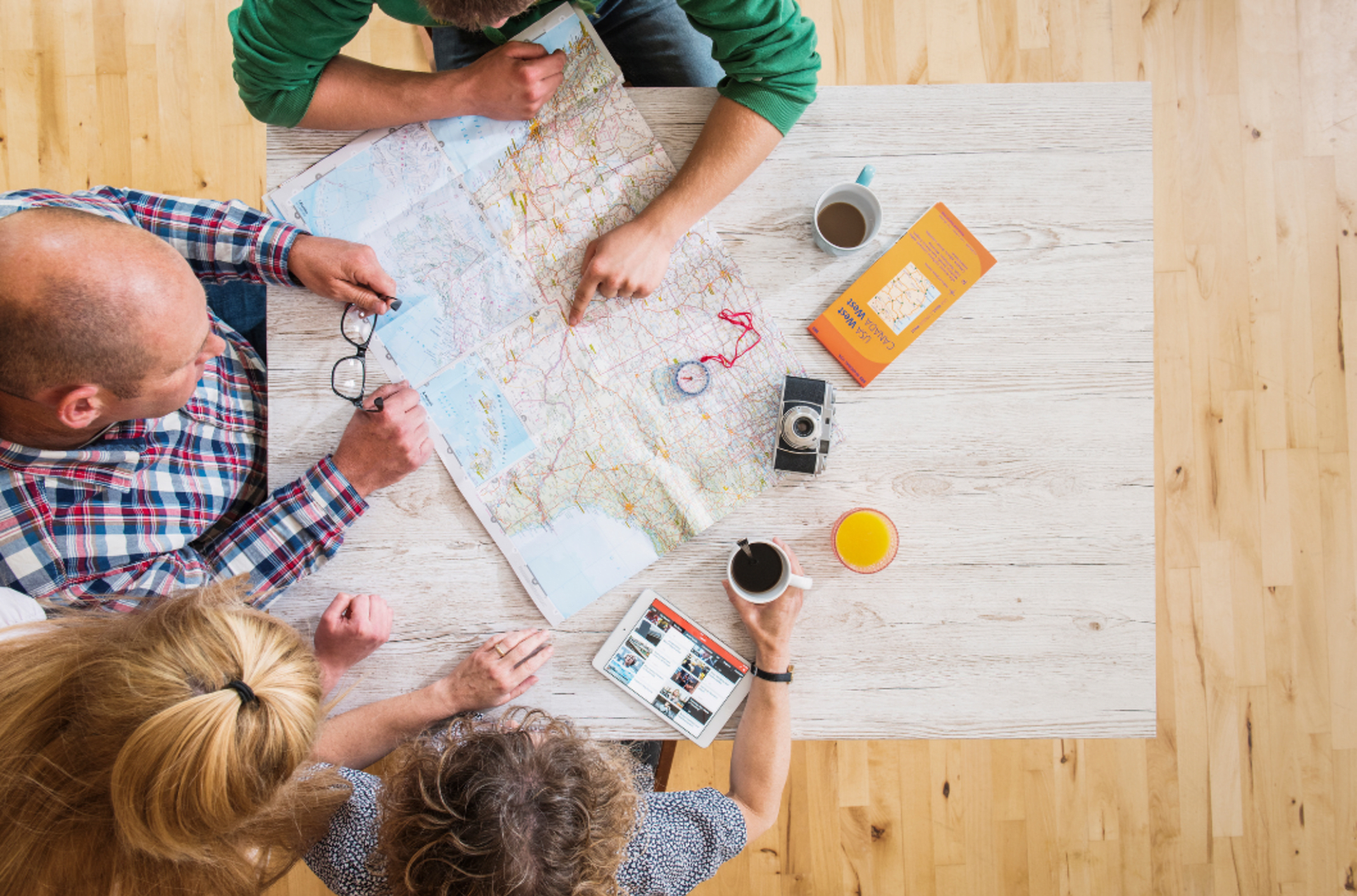Family sitting around a table with a map planning a holiday