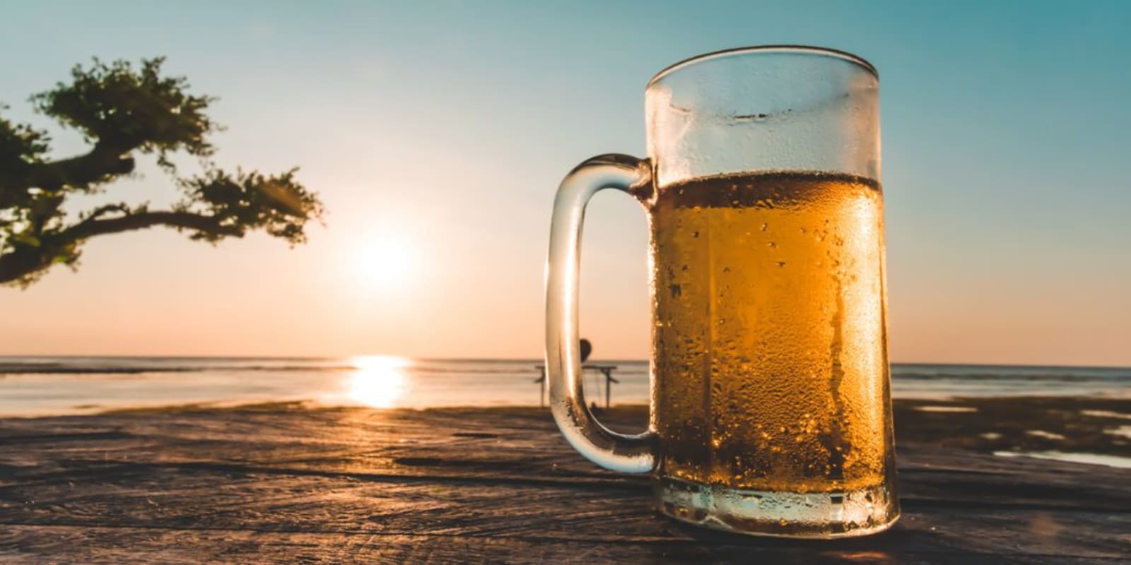 A glass of beer on a table against the sky during sunset in Sicili, Italy