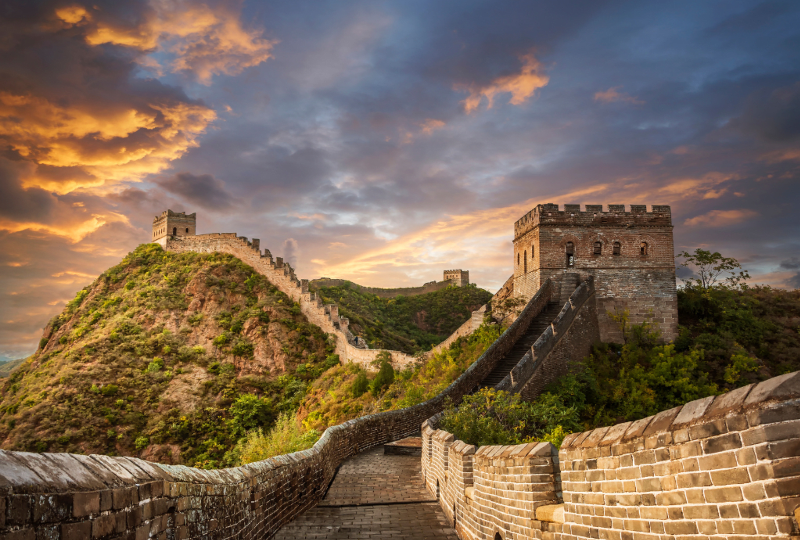 Looking along the Great Wall of China as it winds its way uphill at sunset