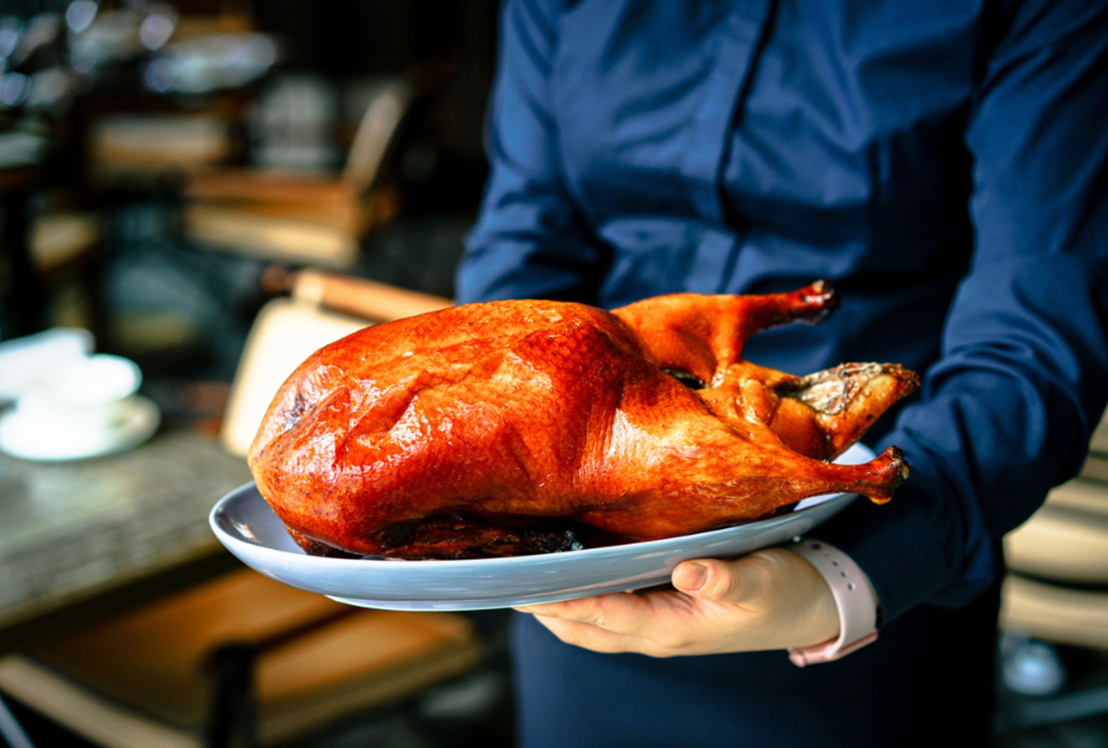 A freshly cooked Peking Duck in the arms of a waiter