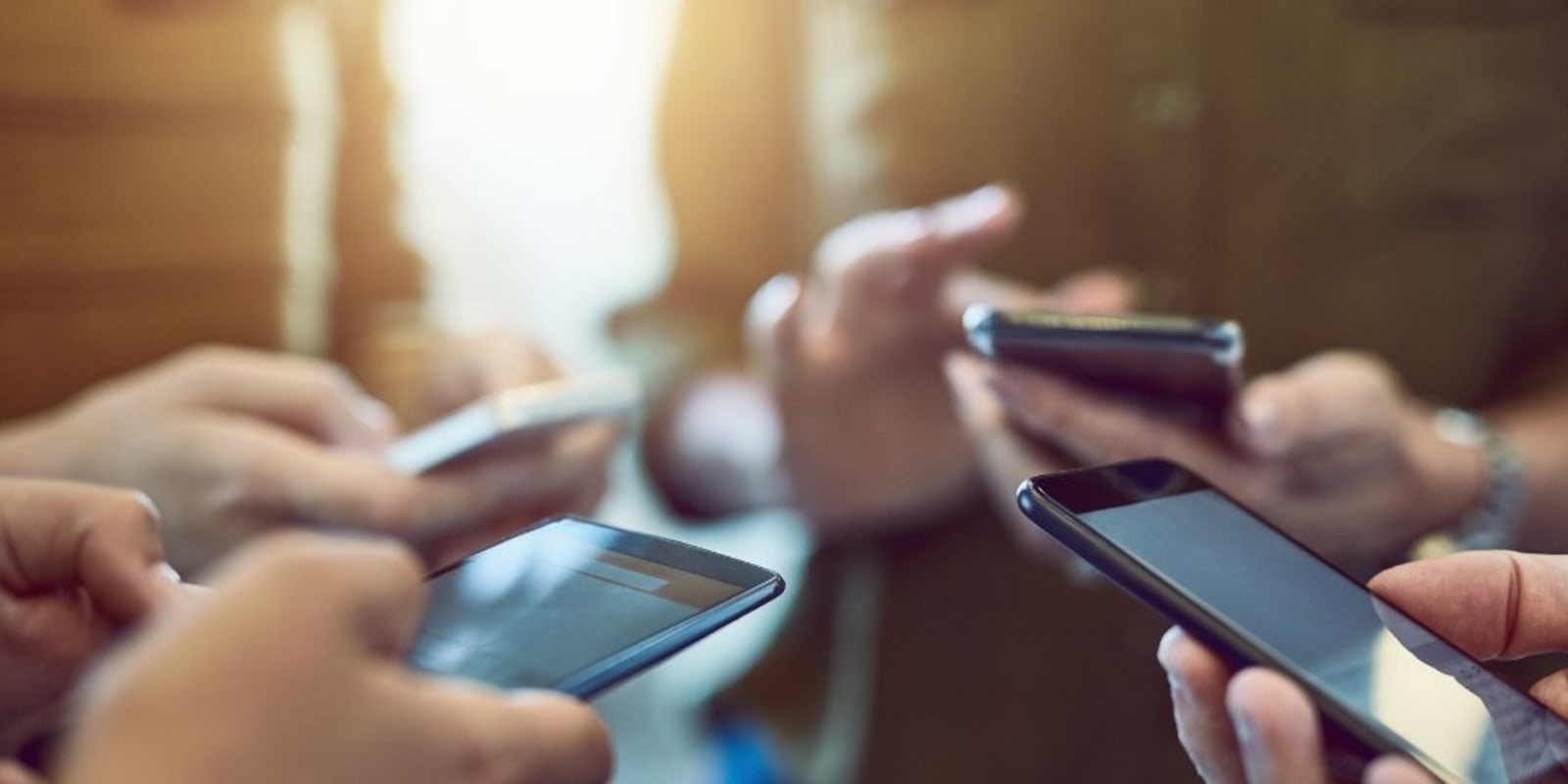 A close up of a group of people on their phones