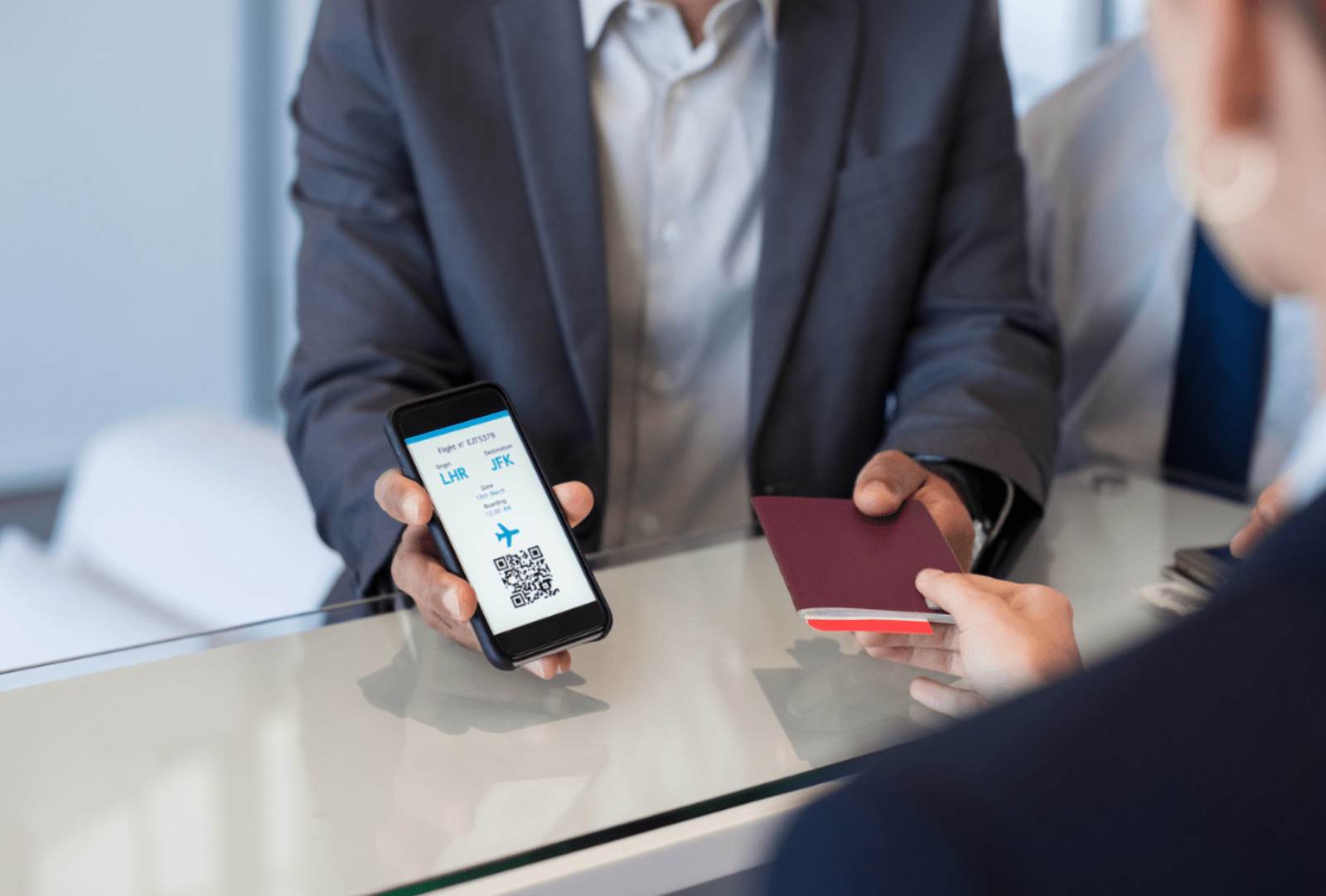 Man displays boarding pass and passport to flight staff