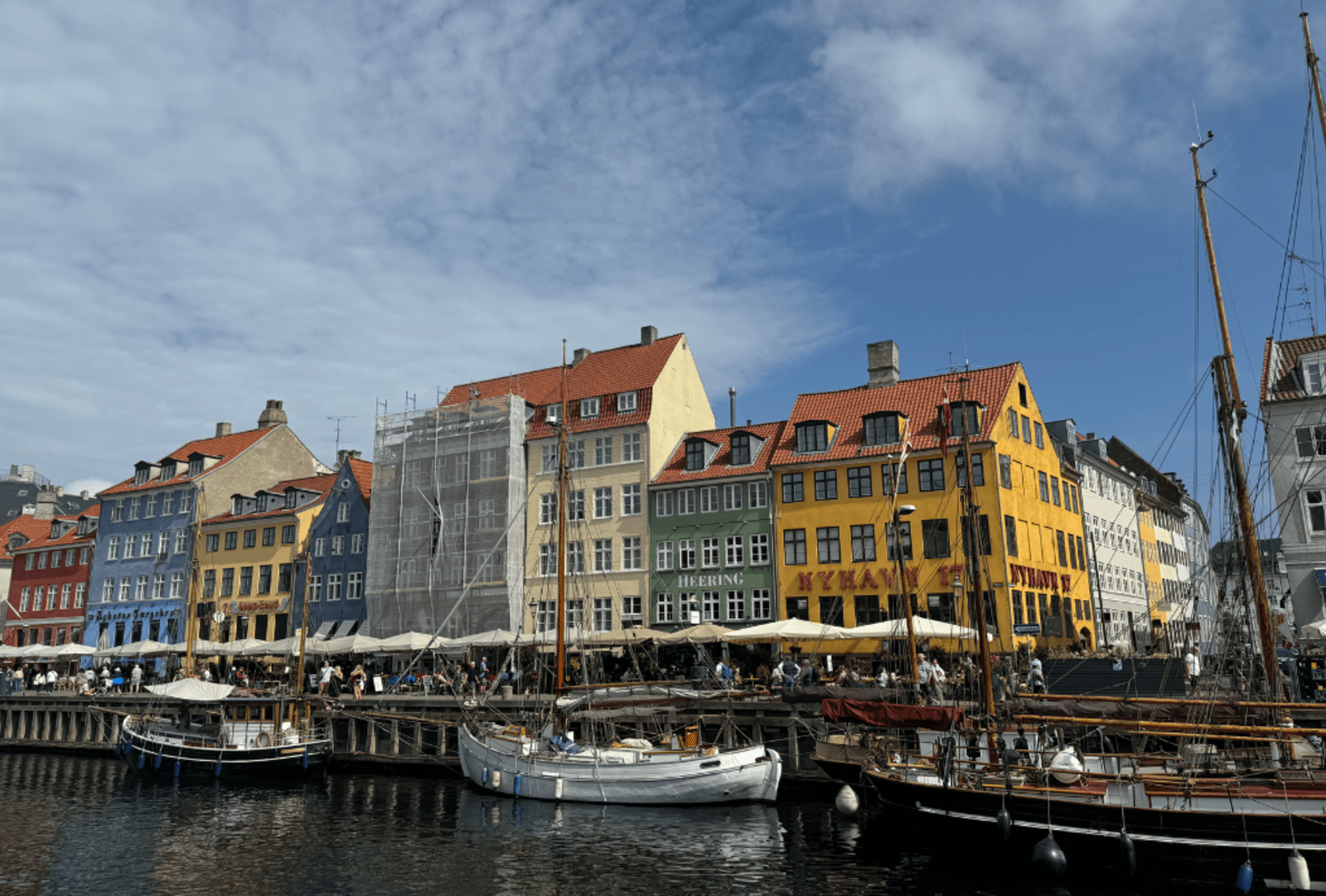 Ornate sailboats docked in front of the colourful buildings of Nyhavn docks