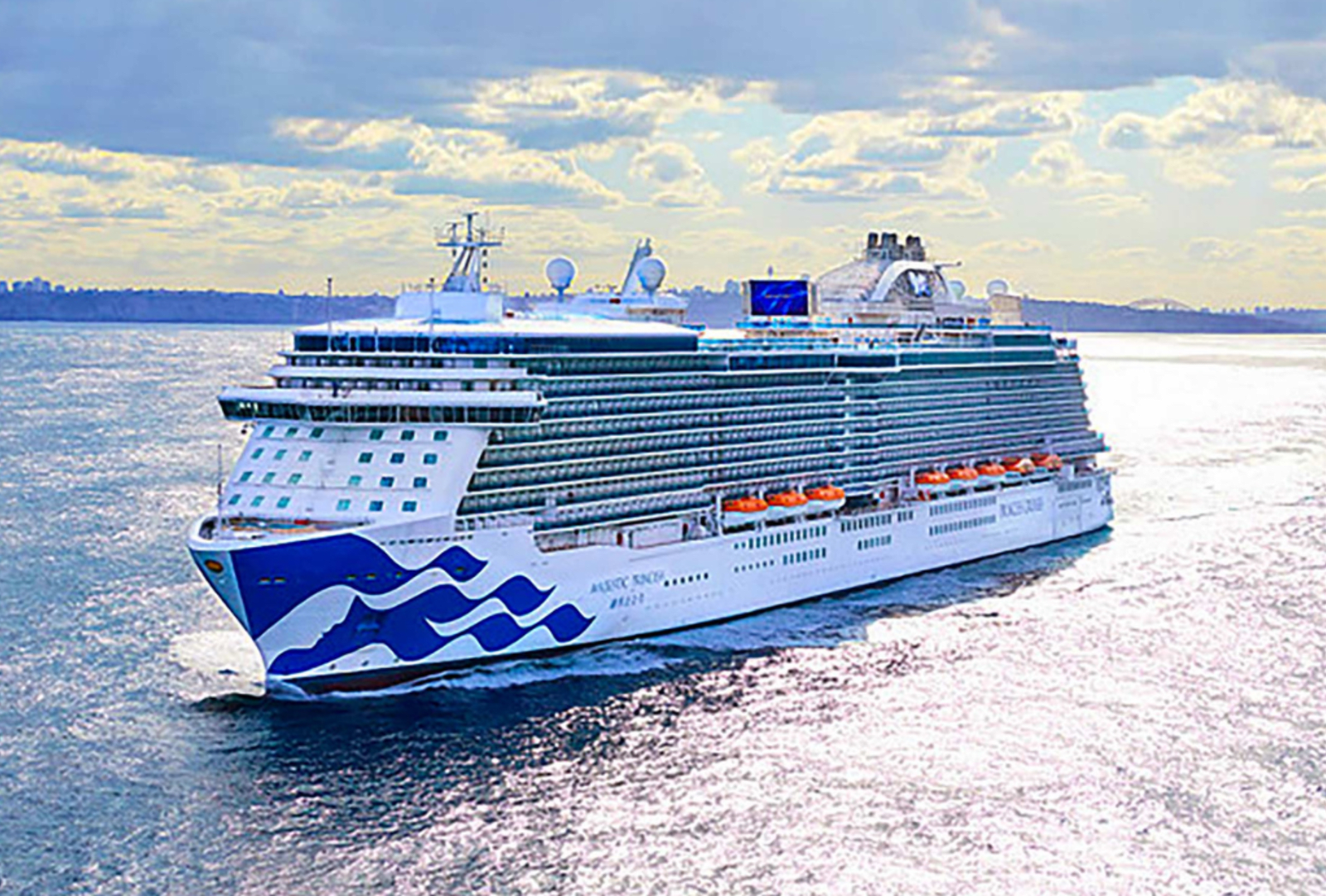 A cruise ship sails on smooth ocean waters