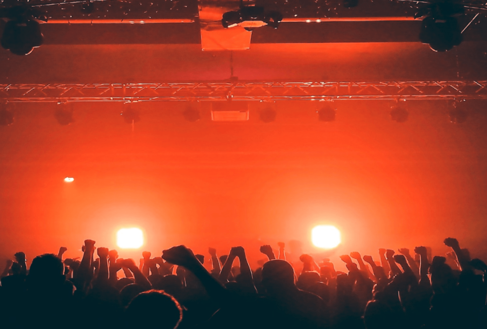 Red light bathes silhouetted revellers in a night club