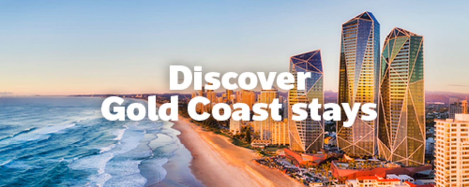 Golden hour over Gold Coast skyline with high rise towers and sandy beach for Discover Gold Coast stays
