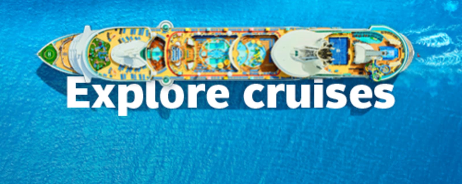 Aerial view of a cruise ship with pools and waterslides sailing turquoise ocean for Explore cruises