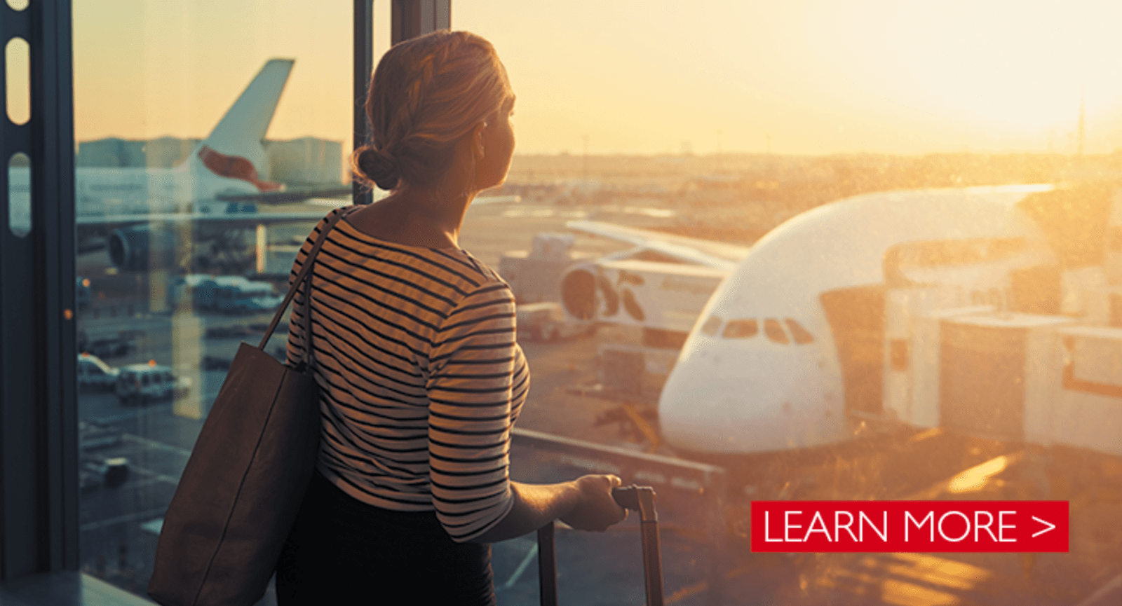 Woman looking at airplanes on a runway at sunset