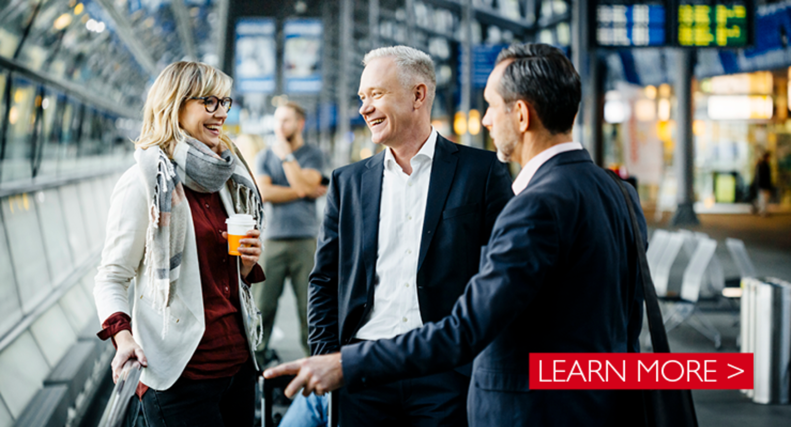 Elderly white businessmen and businesswoman on a travellator at an airport
