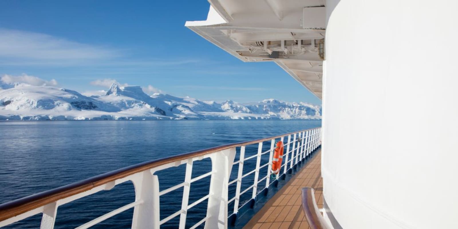 A cruise ship sailing past snowy mountains