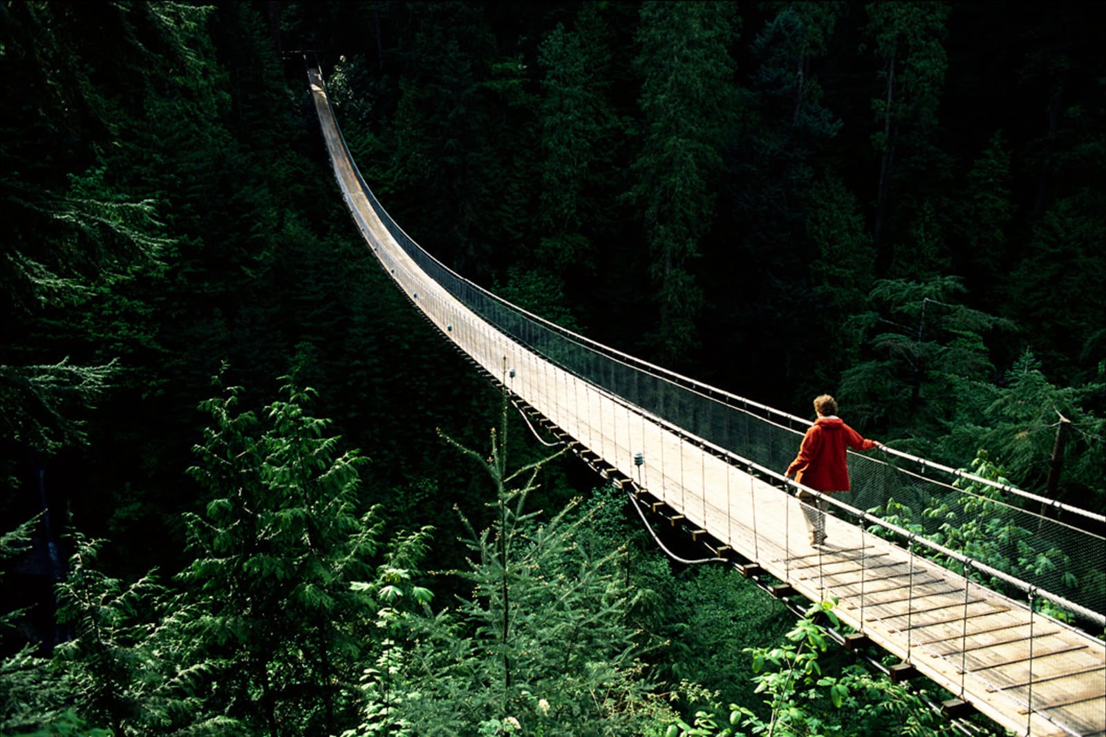 A person walking across Capilano Suspension Bridge in North Vancouver