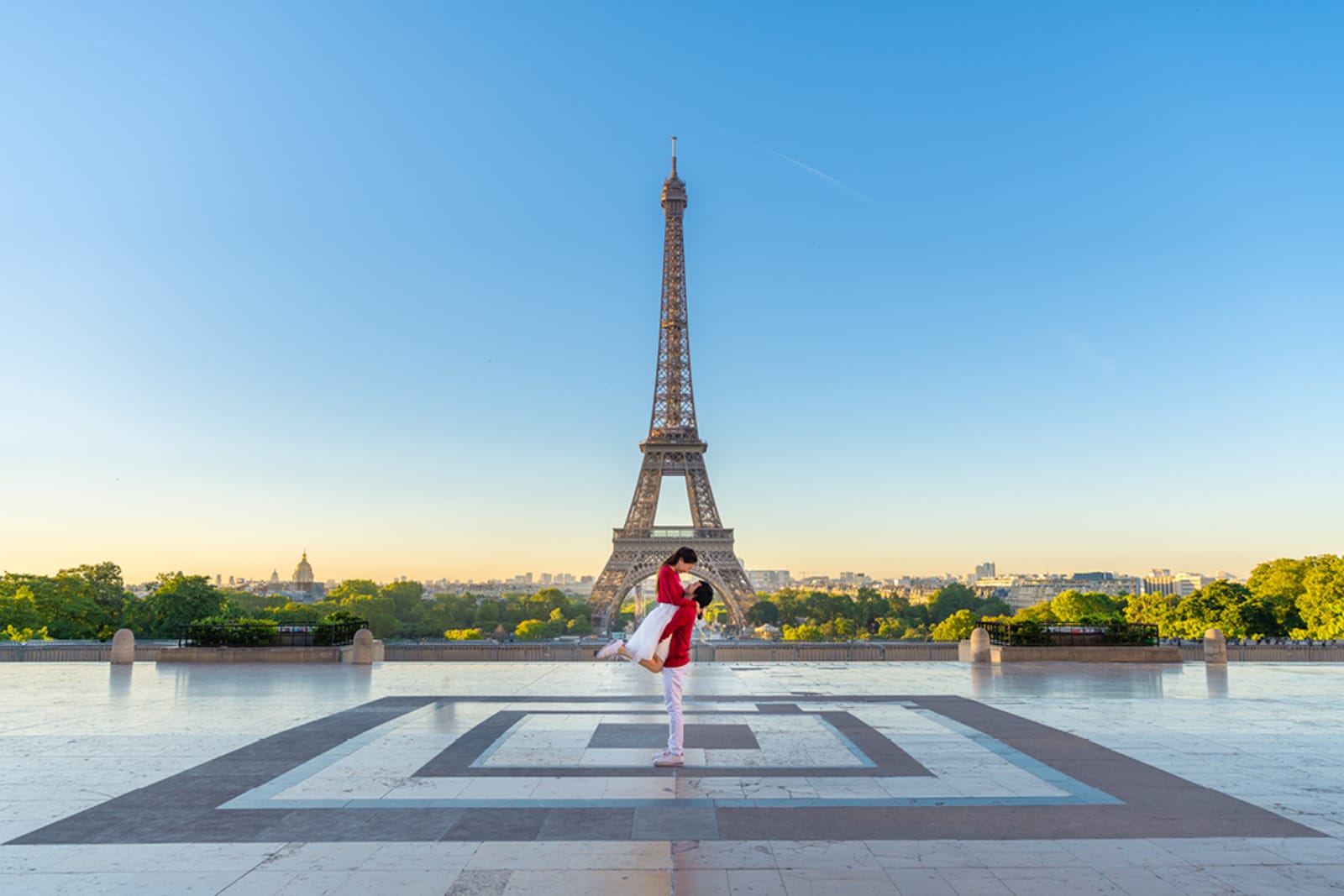 A couple embracing in front of the Eiffel Tower