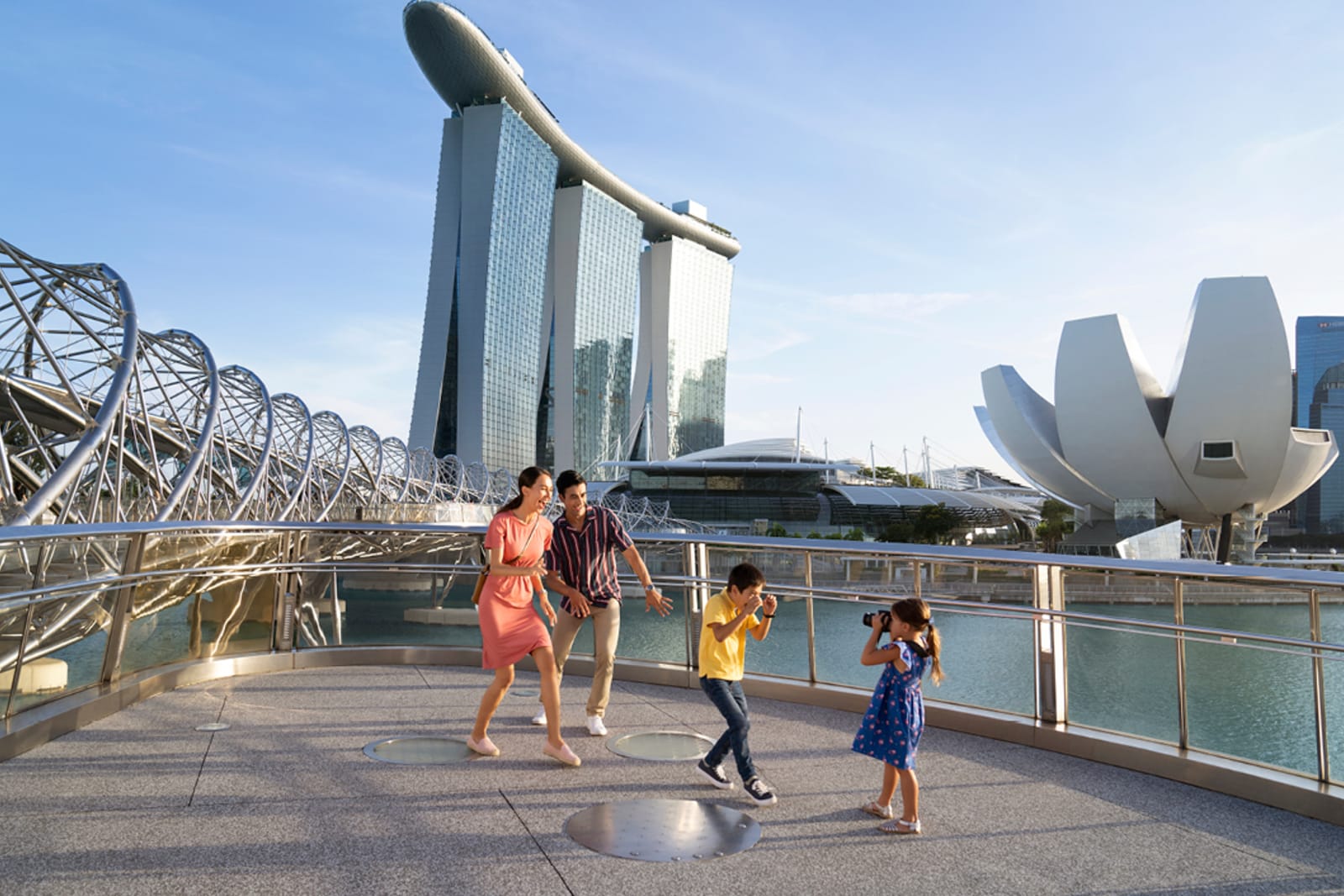 A family in the front of Marina Bay Sands and Helix Bridge in the background
