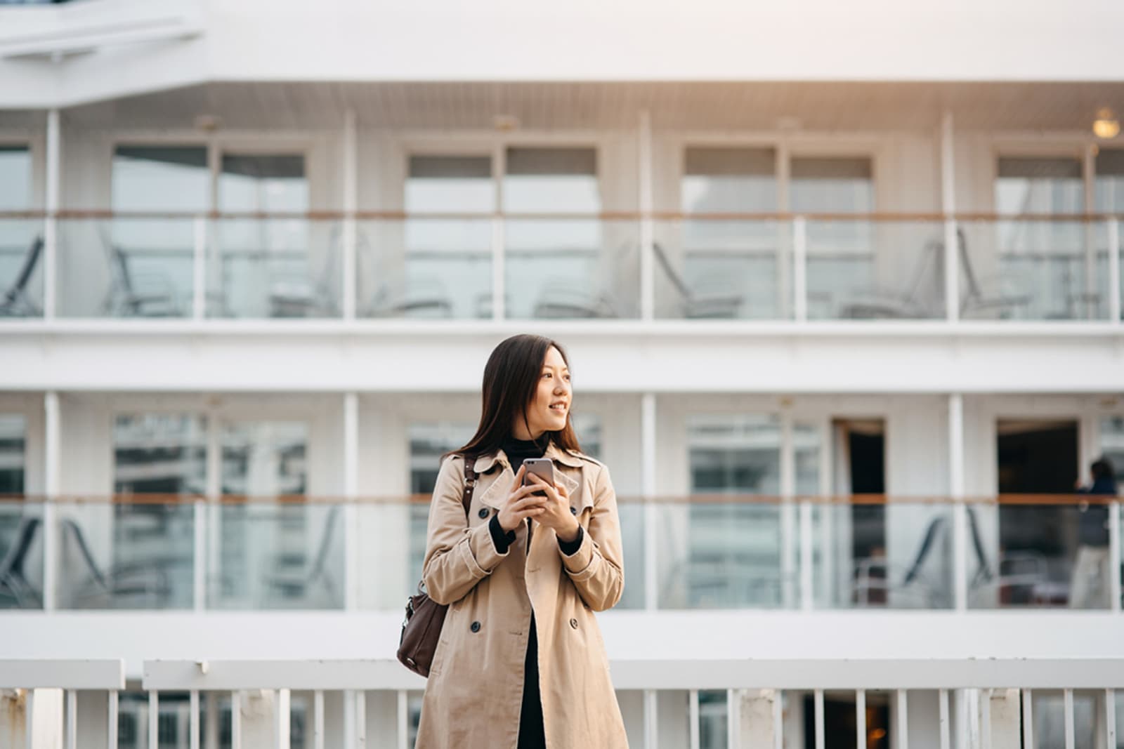 A woman using her phone on a cruise ship pier
