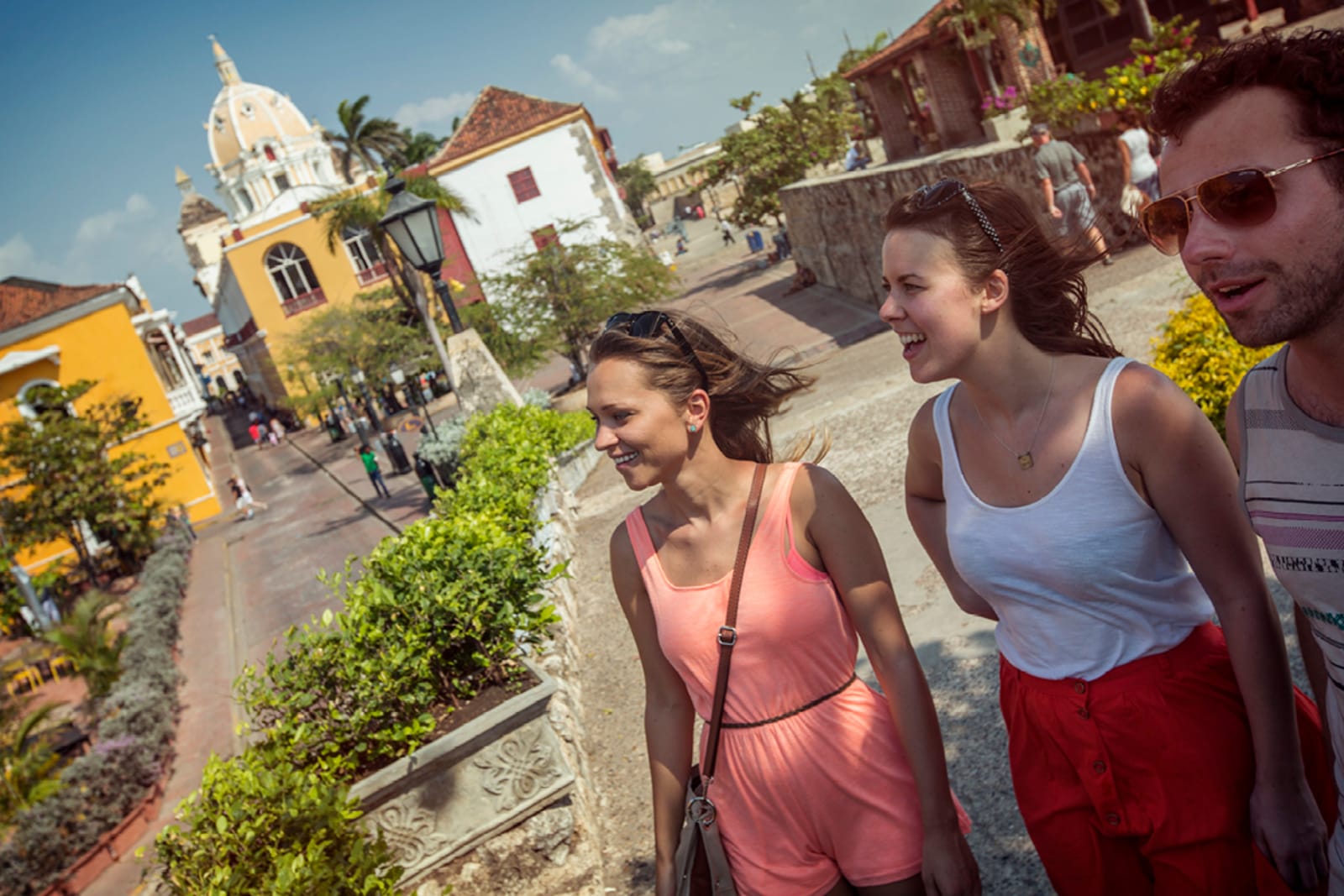 A group of three tourists explore the streets of Colombia