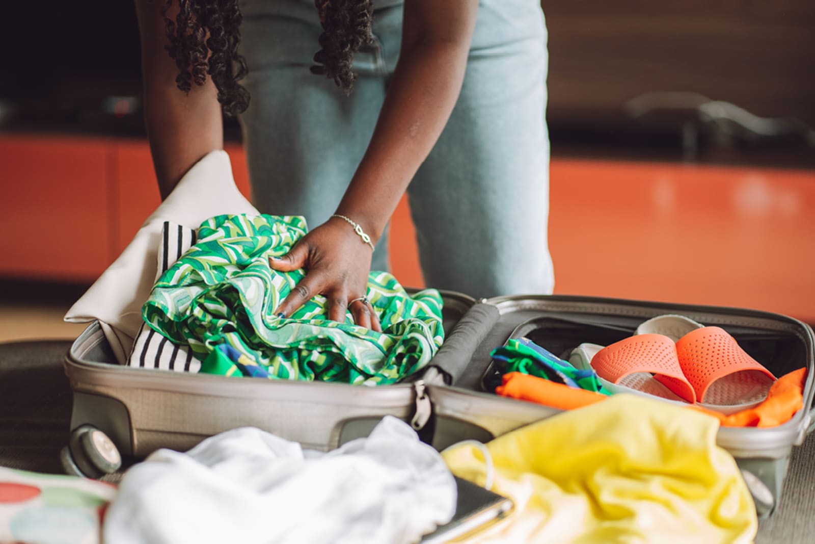 A traveller packing their suitcase for a beach vacation
