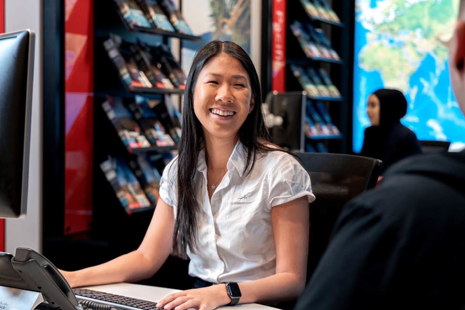 A Flight Centre travel consultant working with a client in store
