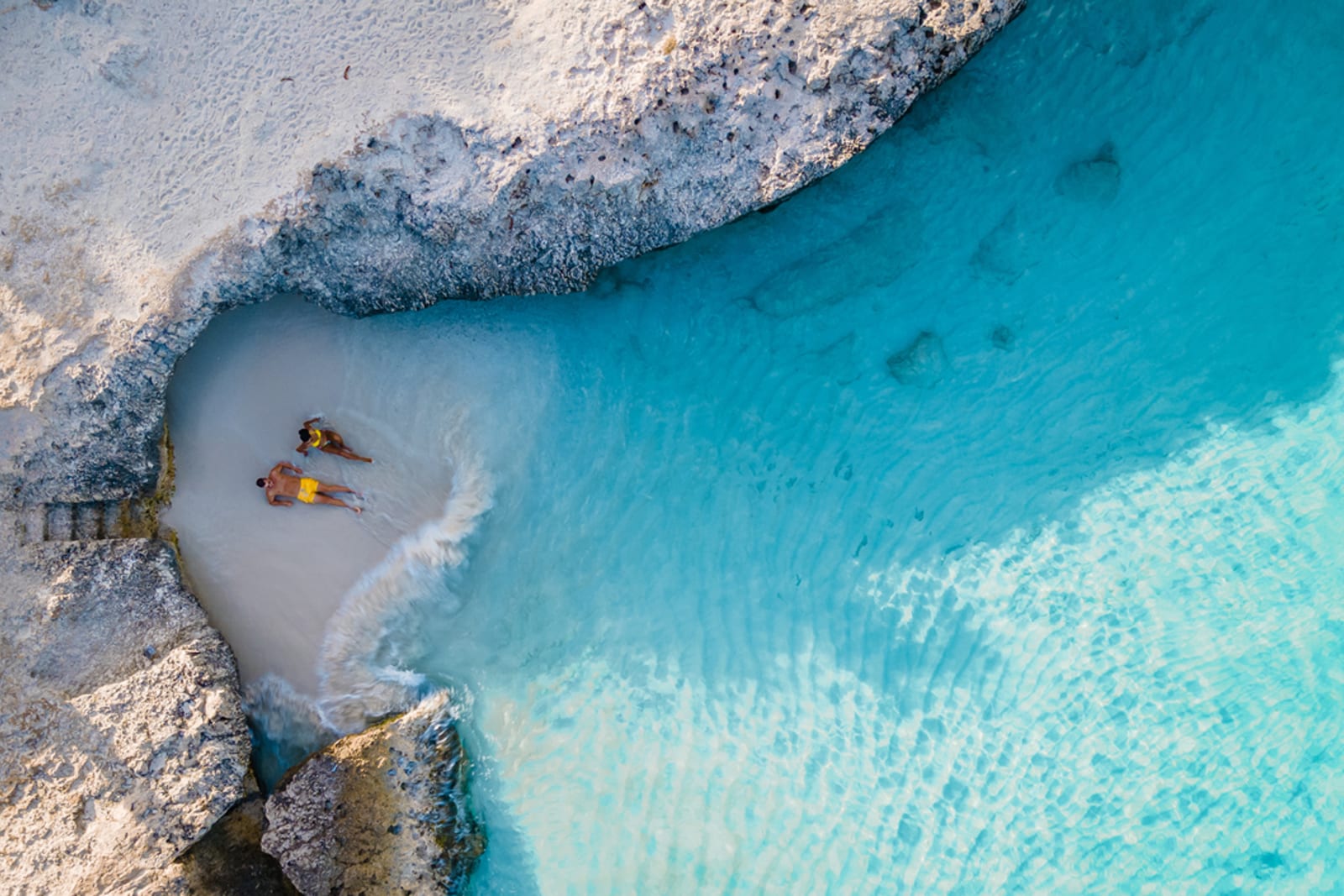 A couple relaxing on a small, secluded beach in Aruba