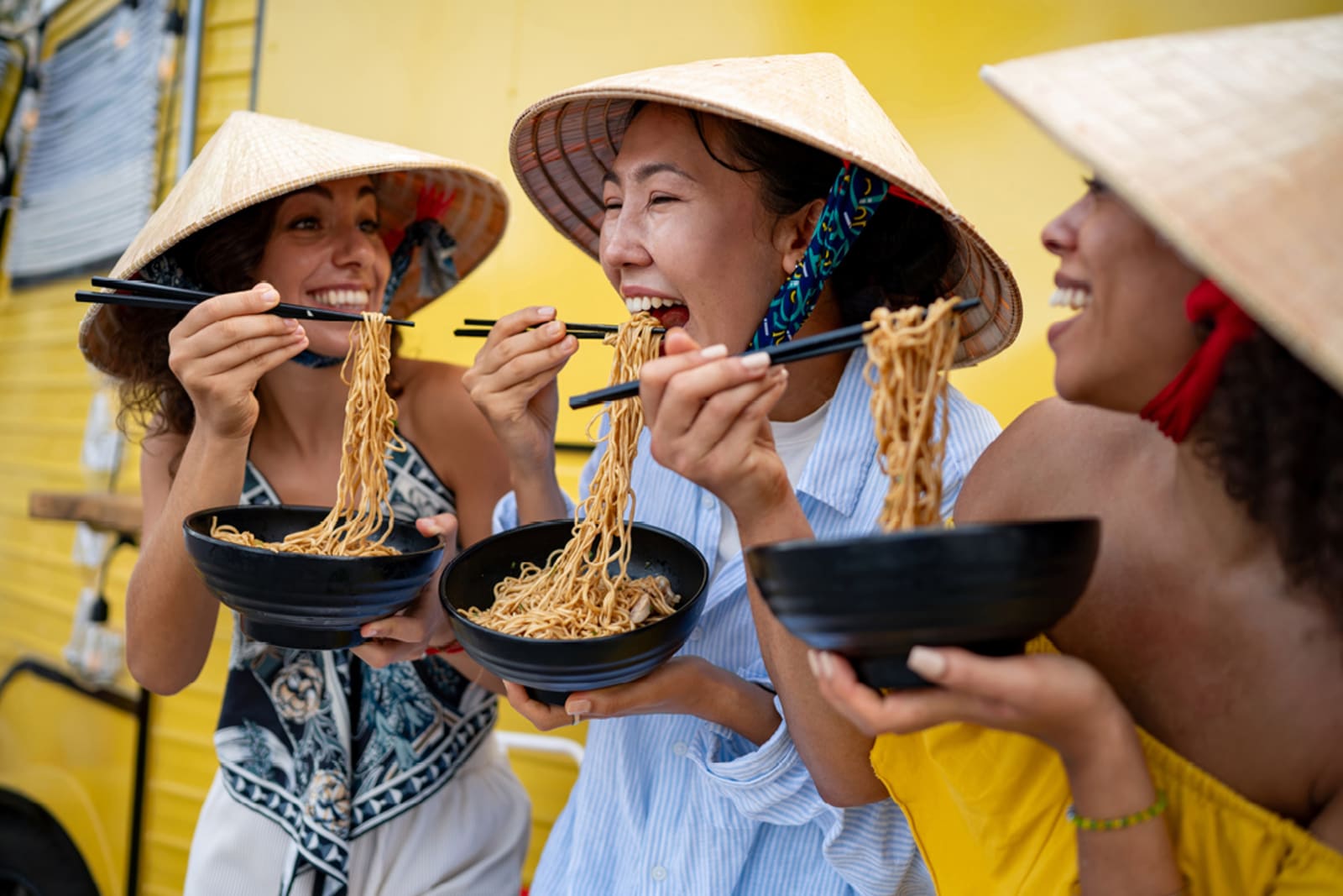 Travellers eating noodles while on a food tour in Asia
