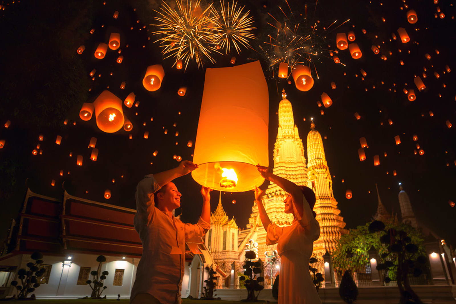 Travellers releasing floating paper lantern