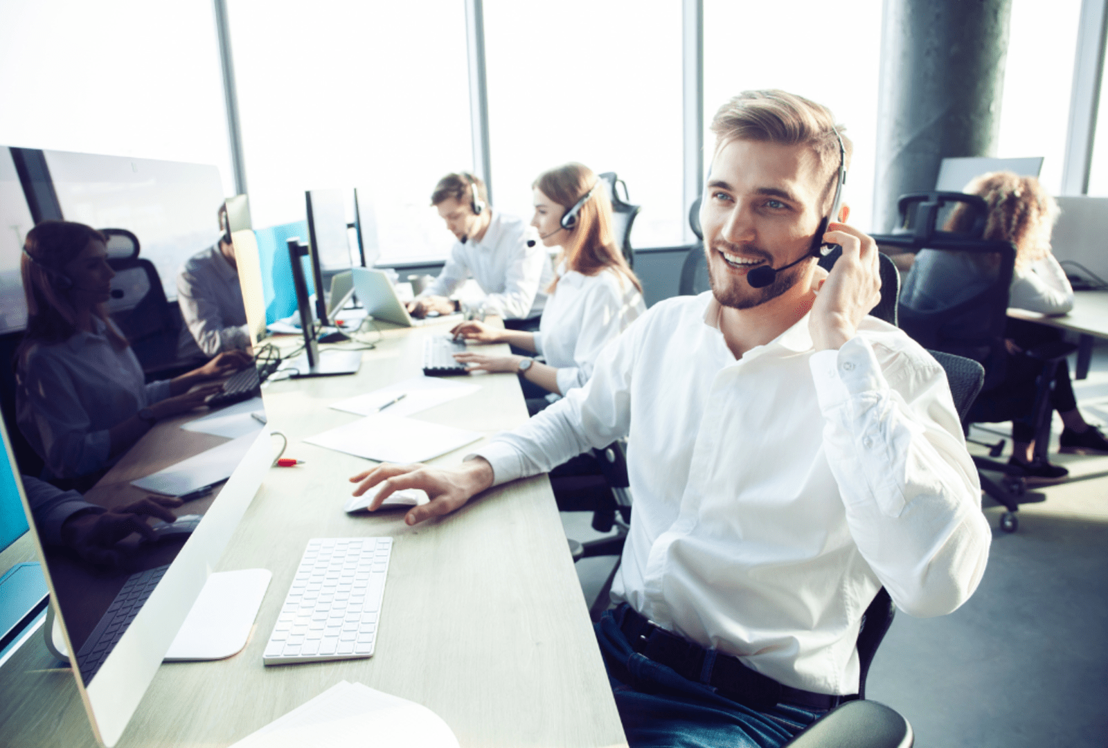 A customer support Travel Manager with a headset talks to client