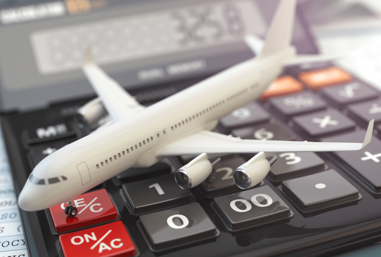 A model jet airliner sits on an accounting calculator