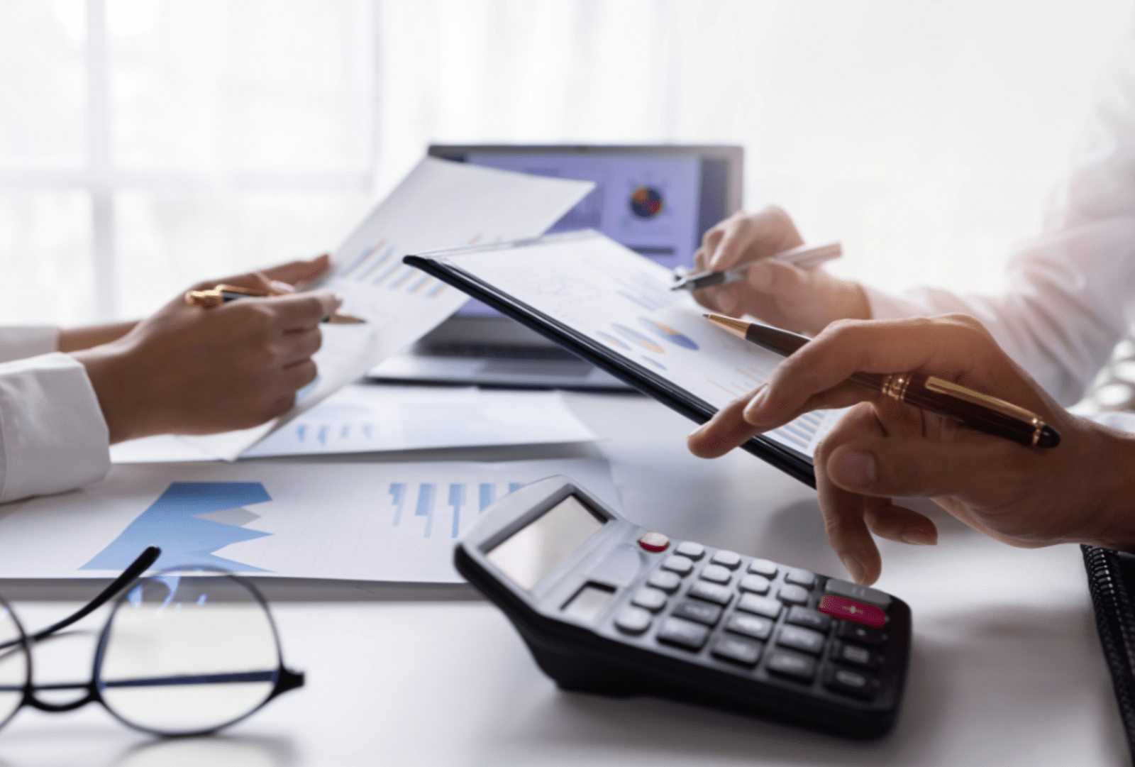 A group of business people gathered around a table discussing an accounting presentation