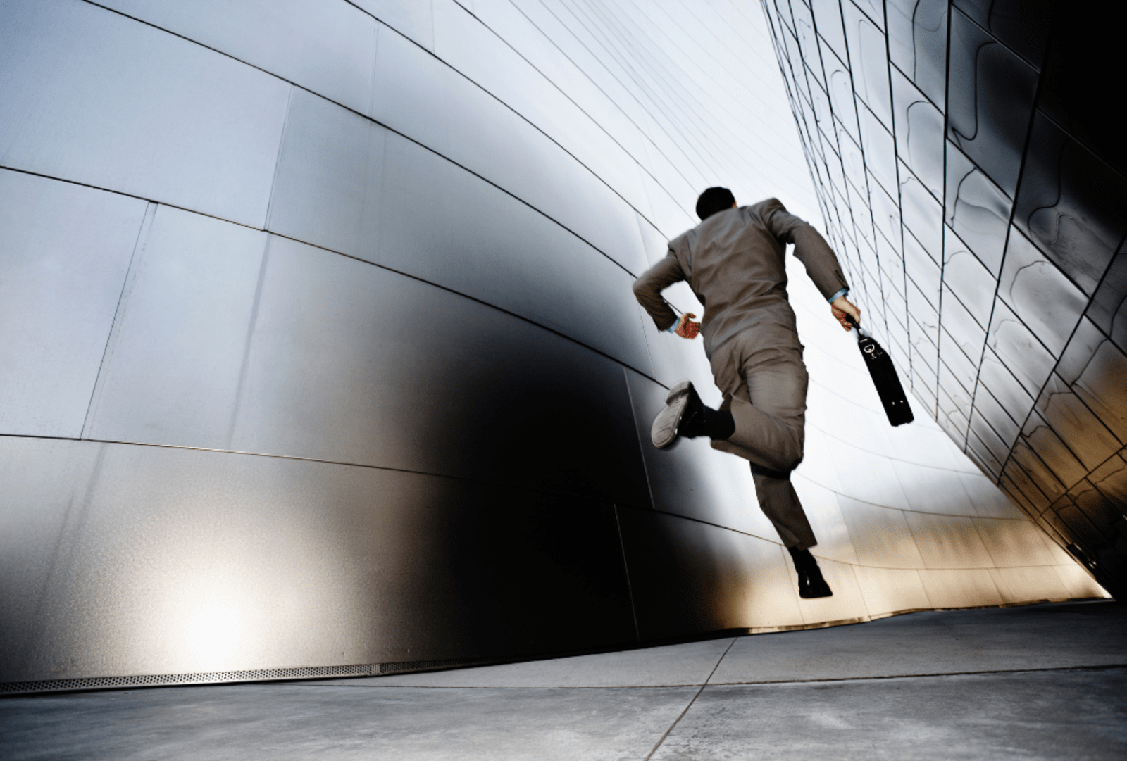 A businessman runs down an urban alleyway