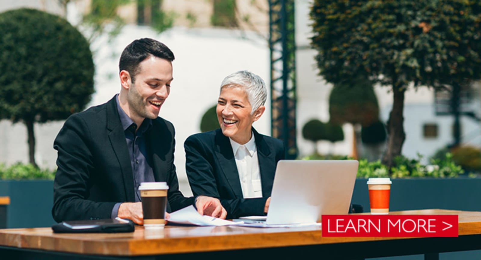 White businessman and elderly businesswoman having a meeting outside