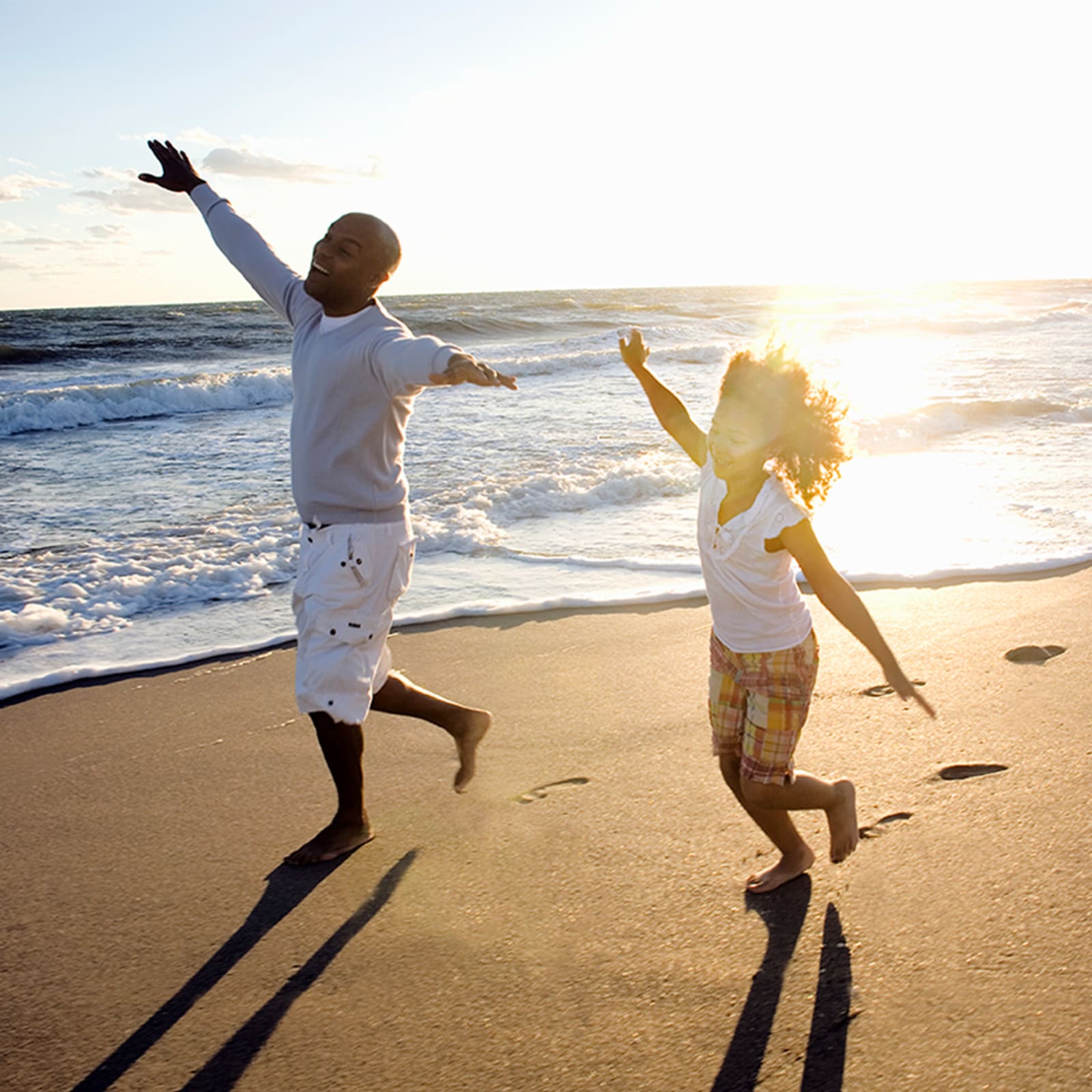 Family playing on the beach in Florida at sunset