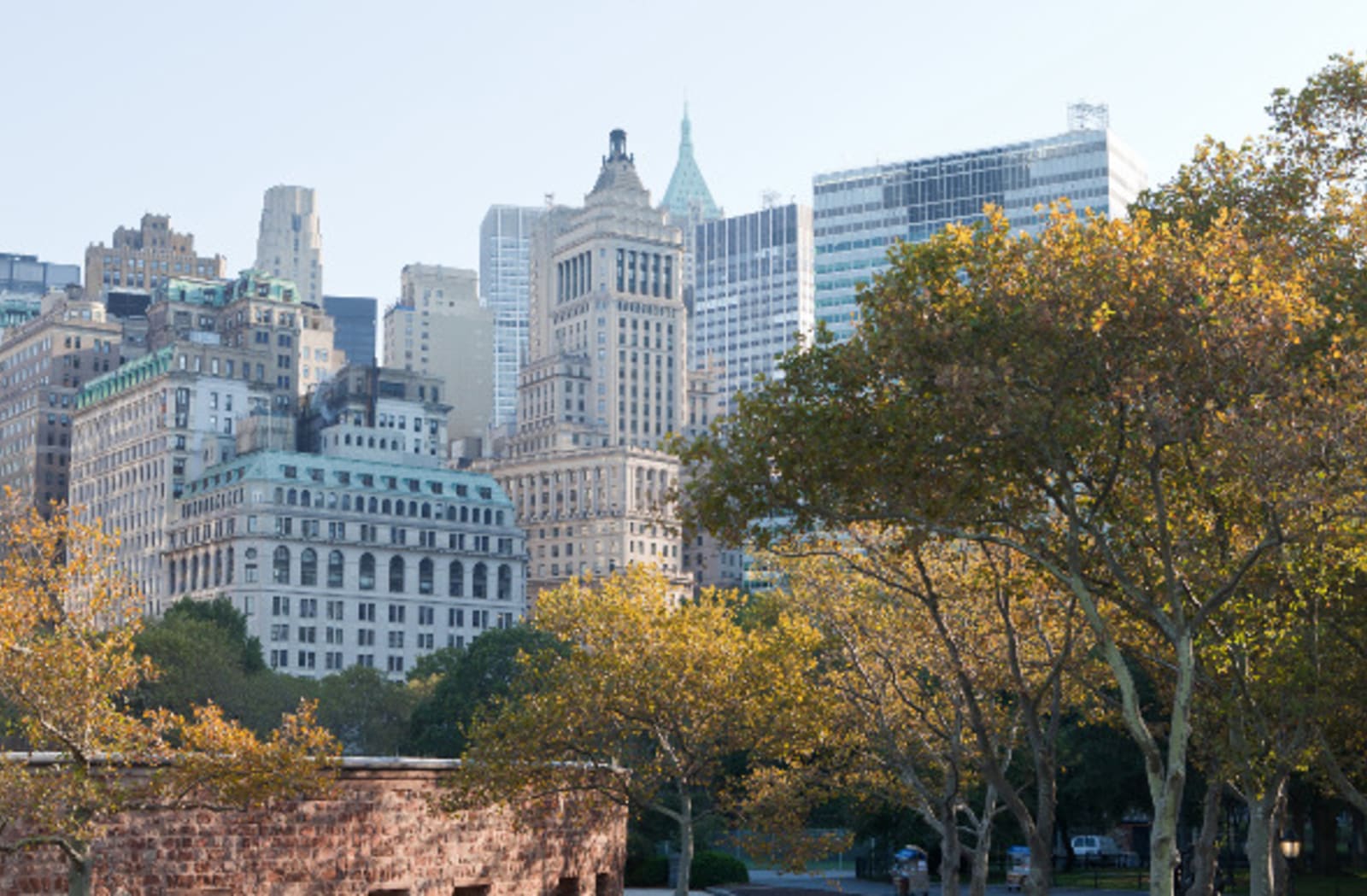 Green trees and city skyline seen from Battery Park in New York